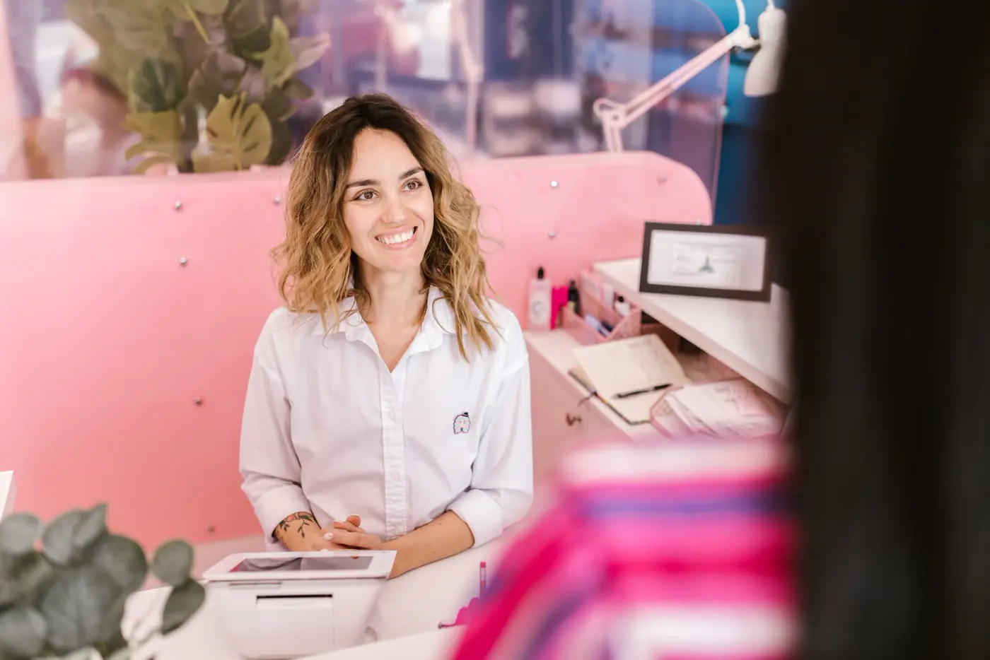 Smiling receptionist at a salon front desk